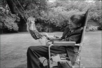 England. Cambridge. Professor Stephen Hawking in his garden with his daughter on a swing. 1977