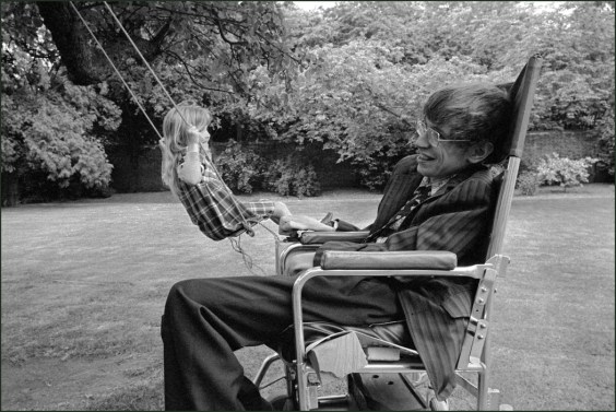 England. Cambridge. Professor Stephen Hawking in his garden with his daughter on a swing. 1977