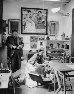 Diego Rivera and Frida Kahlo read and work in a studio.