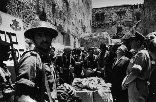 East Jerusalem, 7th June 1967.In the course of the War of Independence in 1948, the Jewish Quarter of the Old City of Jerusalem was captured by the Jordanian "Arab Legion", and from then on Jewish worshippers were denied access to the Western Wall (also known as the Wailing Wall).The Israeli Paratroop Brigade burst into the Old City and from there descended to liberate the Western Wall. Israeli Prime Minister David BEN GURION witnessed the reclaiming of the Wailing Wall