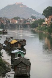 In front of the old town of Srinagar, India, houseboats are rocking on the waters of the Jhelum River