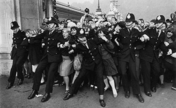 Excited Beatles fans are trying to keep London police in check on October 26, 1965 in front of Buckingham Palace.